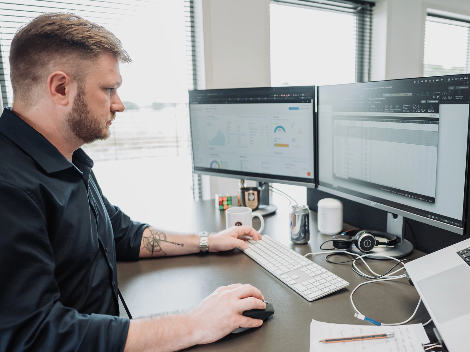 Lasse arbejder fokuseret ved skrivebordet med dashboards og data.